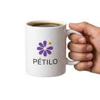 Mug en céramique blanc avec logo floral et café, tenu à la main sur fond blanc